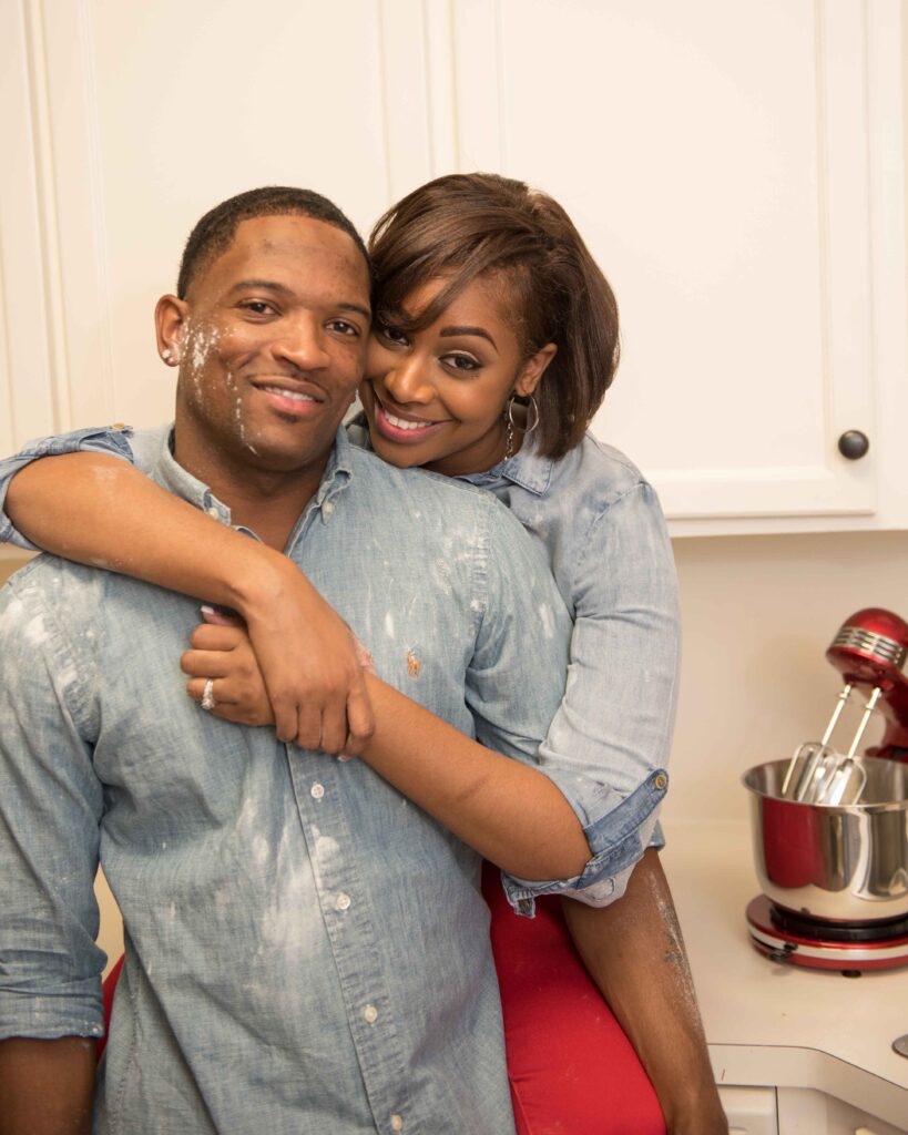 Couple in matching denim shirts embracing playfully with flour on their faces