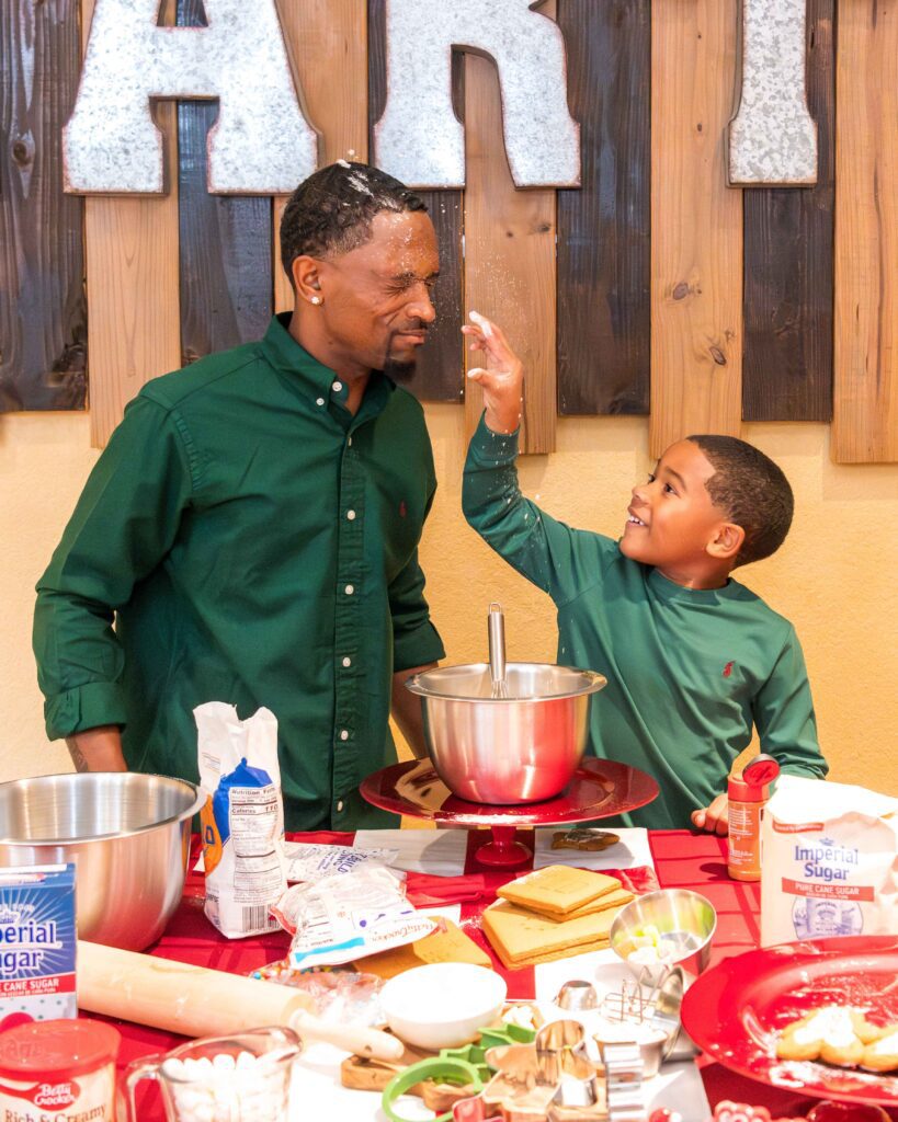 Young boy playfully tossing flour at his dad during a photo shoot.