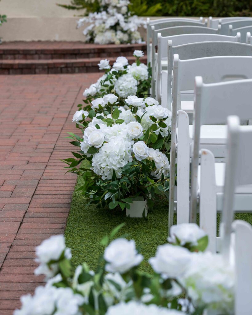 White aisle flowers and ceremony chairs for an outdoor wedding at The Springs Cypress